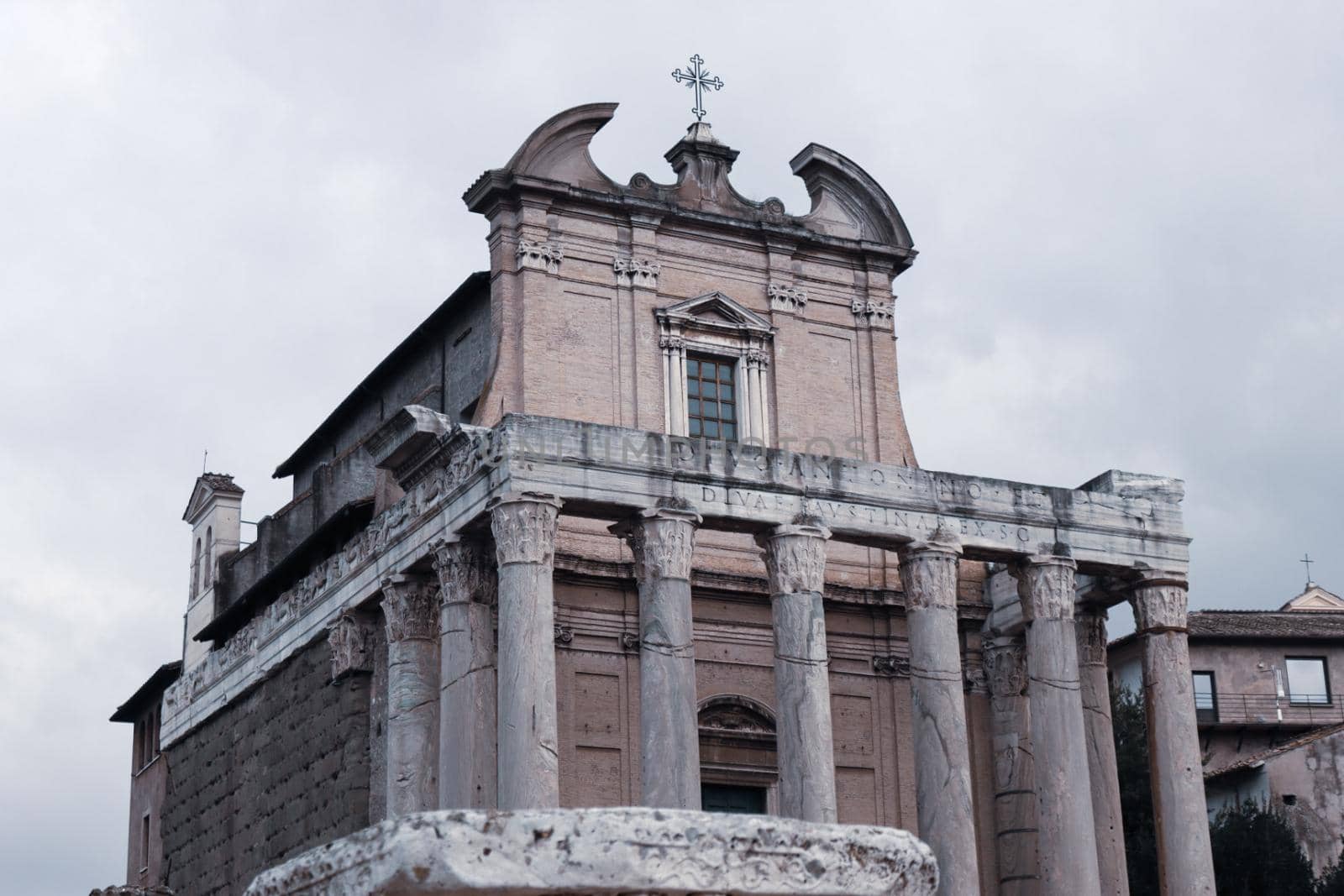 ROME, ITALY - February 05, 2022: Panoramic view around the Colosseum in city of Rome, Italy. Cold and gray sky in the background. Macro photography of the green parks with the old buildings.