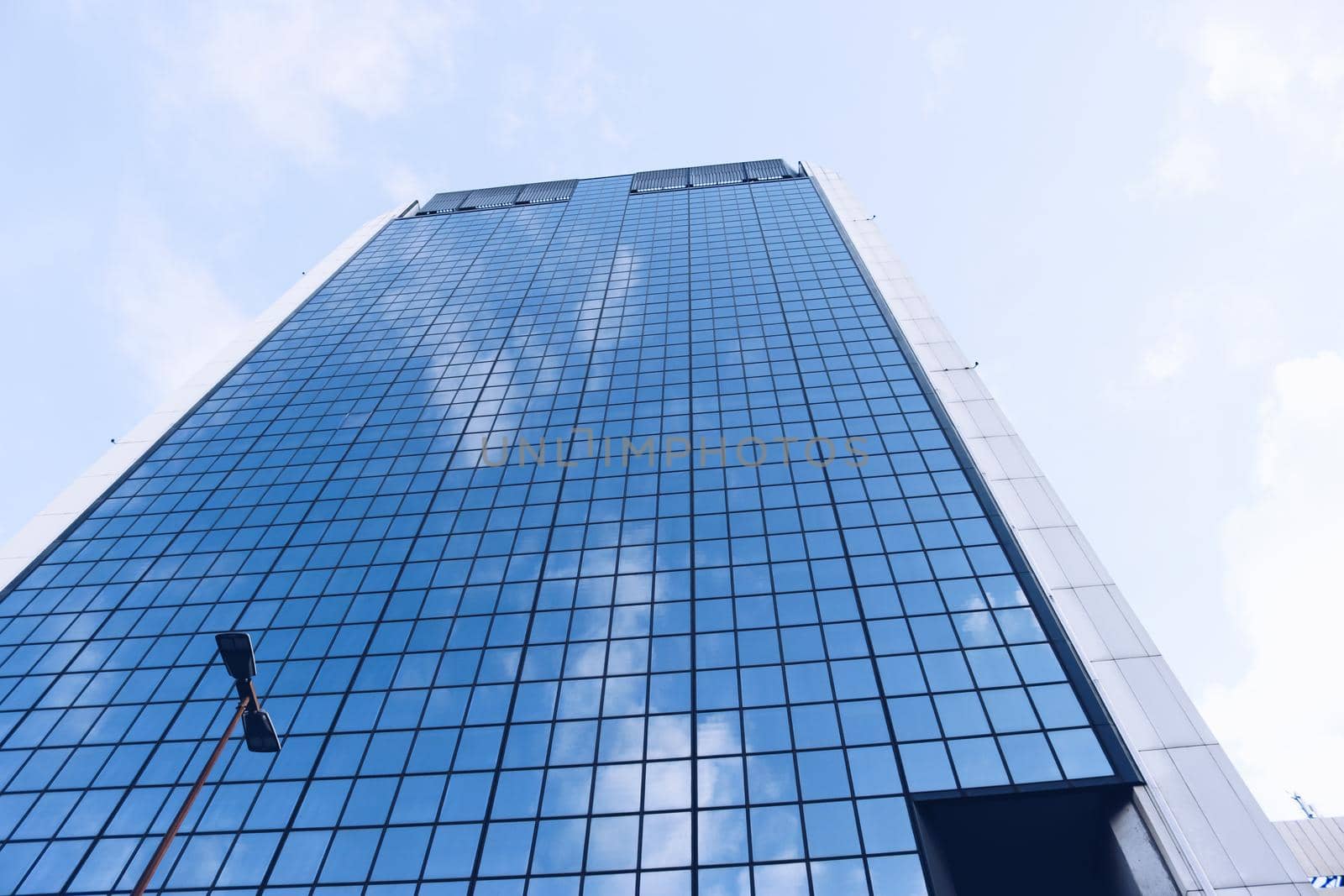 Genova, Italy-January 29, 2022: Beautiful modern high-rise buildings against the sky. 3d illustration on the theme of business success and technology. clouds reflection on the mirror.Industrial zone.