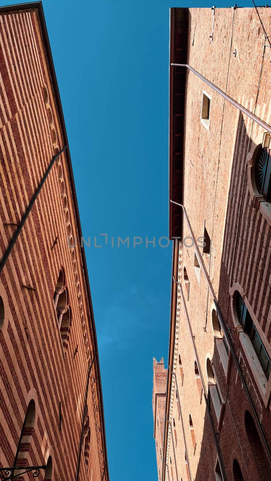 Verona, Italy - March 19, 2022: Aerial view of Verona historical city centre, Ponte Pietra bridge across Adige river, Verona Cathedral, Duomo di Verona, red tiled roofs, Veneto Region, Italy.