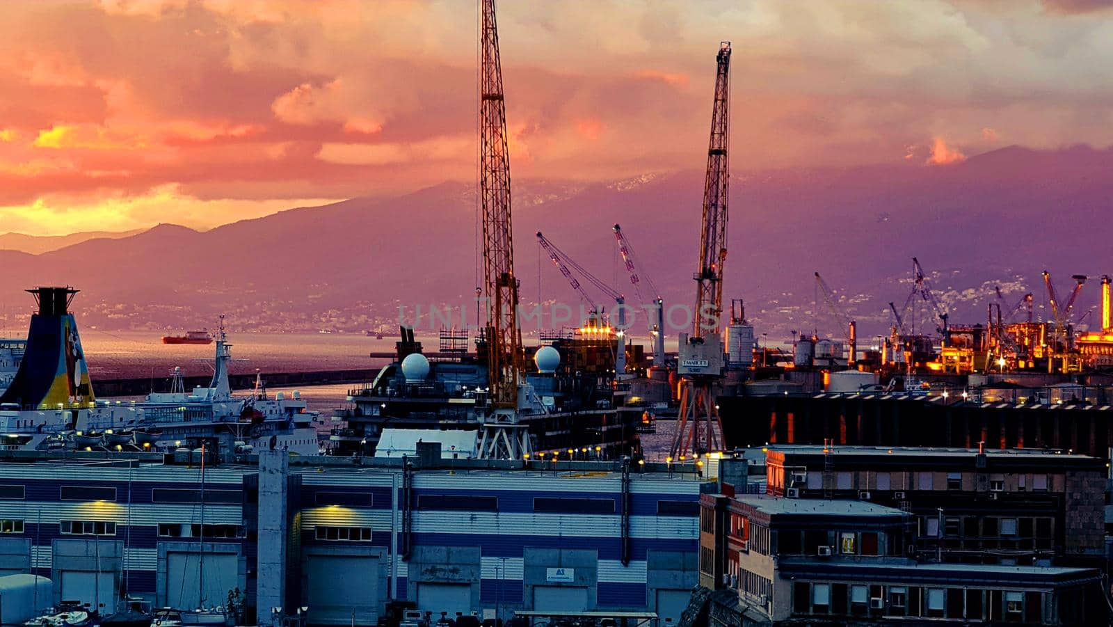 Genova, Italy - May 07, 2022: Panoramic view from the sea to the old town, and the port with beautiful sunset. Genoa bay, harbor, yacht at the pier.tourist destinations.