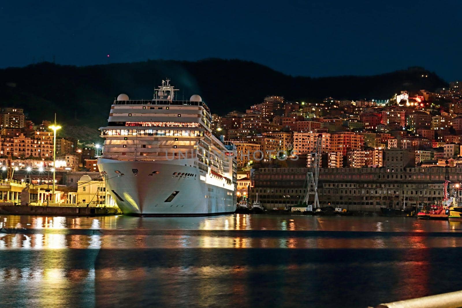 Genova, Italy - May 07, 2022: Panoramic view from the sea to the old town, and the port with beautiful sunset. Genoa bay, harbor, yacht at the pier.tourist destinations.