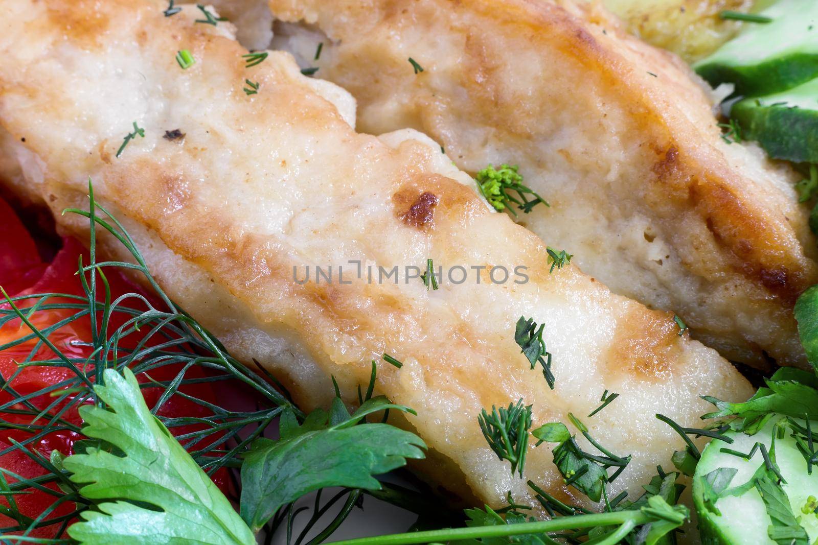 Fried fish with potatoes, vegetables and greens close-up. by georgina198