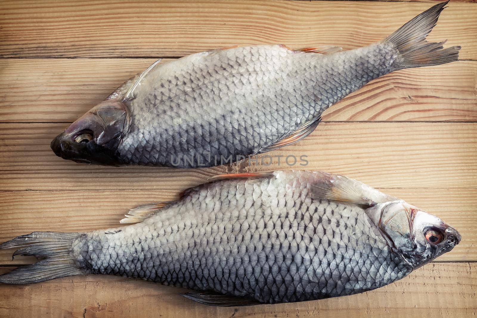 On a wooden table is dried river fish roach. Presented close-up.