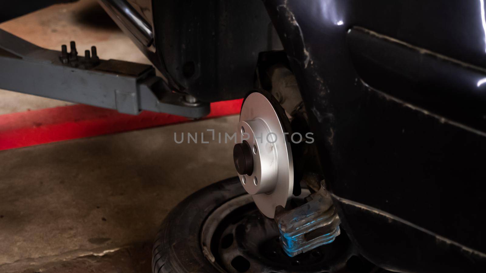 New car brake disc on old car, garage car service by RecCameraStock