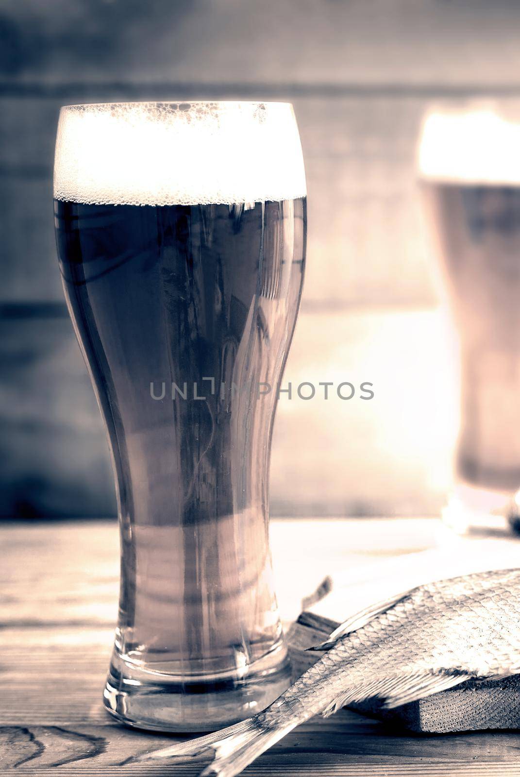 On the table in the kitchen Board with dried fish, roach, next to two glasses of beer.