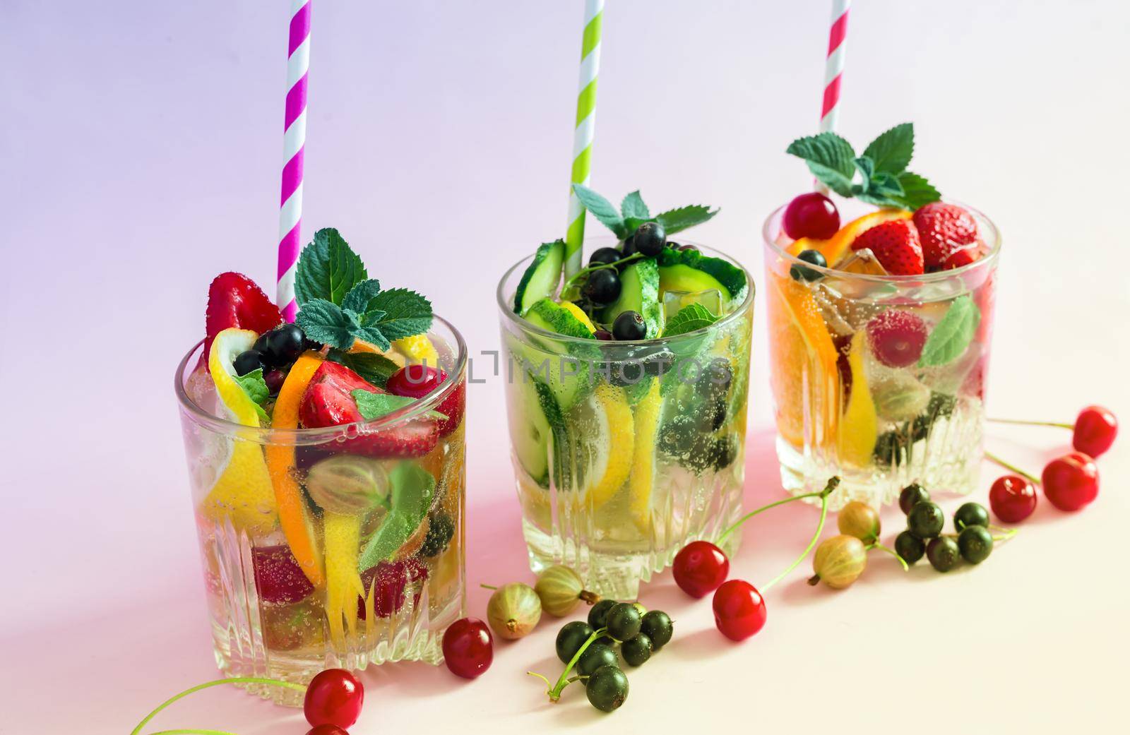 Summer refreshing cocktail of natural fruits and various berries with ice and mint leaves infused with water. Contains lemon, orange, strawberry, cherry, currant.