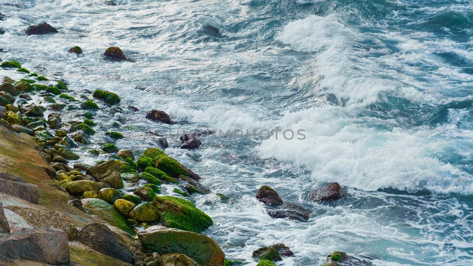 Power of foamy waves breaking over stones. Stormy Black Sea in cold seasons.