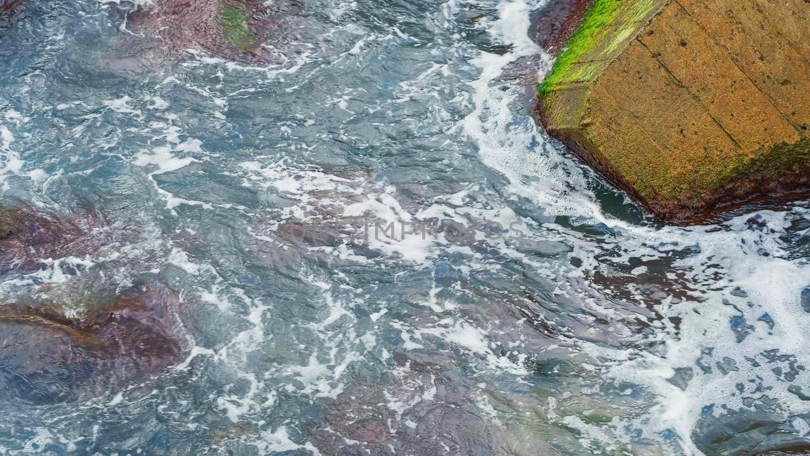 Waves breaking over rocks at seaside by RecCameraStock