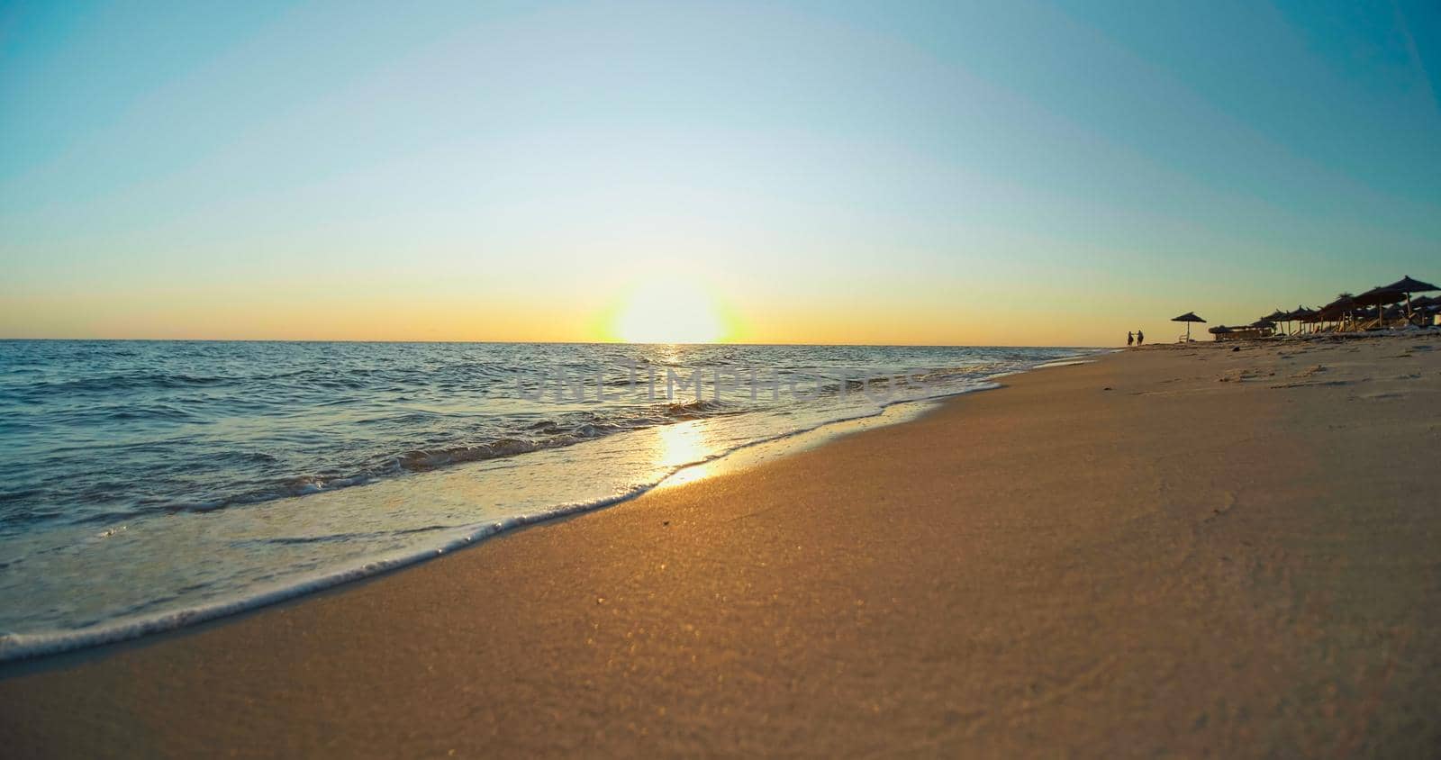 Sunset on the beach, shining golden waves in Tunisia, Africa. Beautiful landscape, travel destinations, enjoying holiday, Mediterranean Sea, vacation seaside.