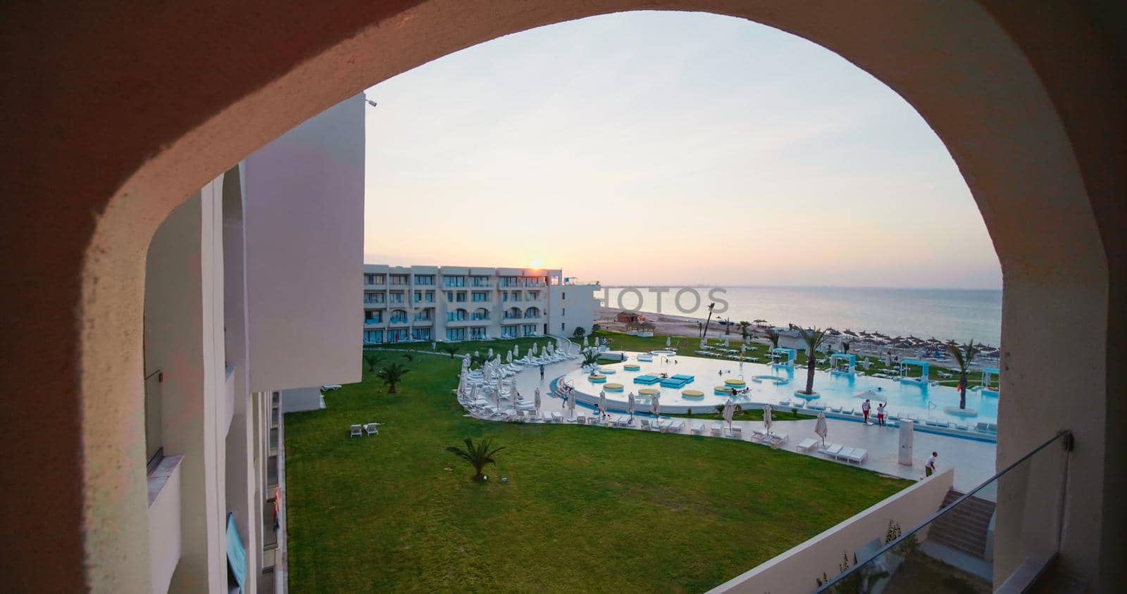 Tunisia, 2022: Luxury hotel on the coast of Tunisia. Beautiful tropical beach front hotel resort with swimming pool, palm trees.