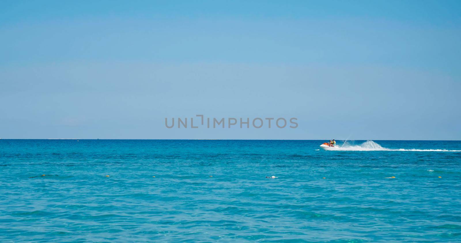 Water scooter on blue. People enjoy summer days riding jet skis, Tunisia, Africa, Mediterranean sea. Summer and travel vacation concept. Vacation activities at sea.