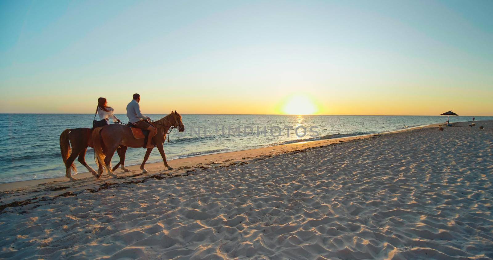 Couple riding on a Tunisian beach by RecCameraStock