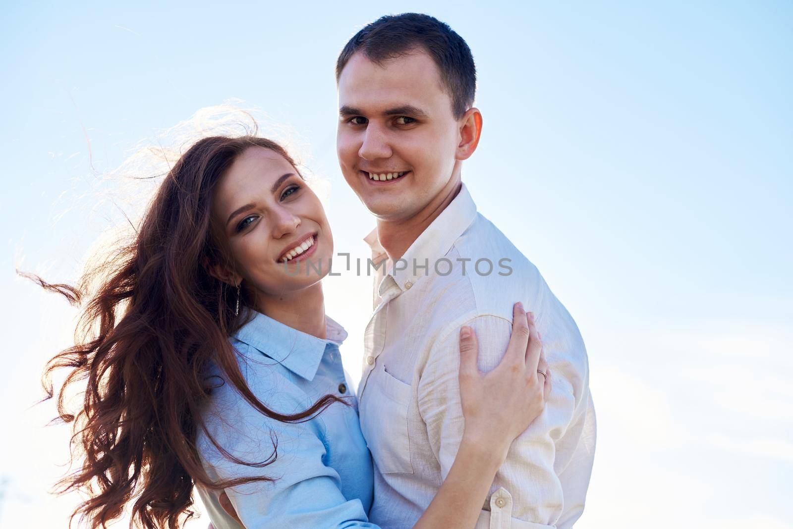 Awesome happy couple have fun in a field sunset background. Lifestyle and travel concept.