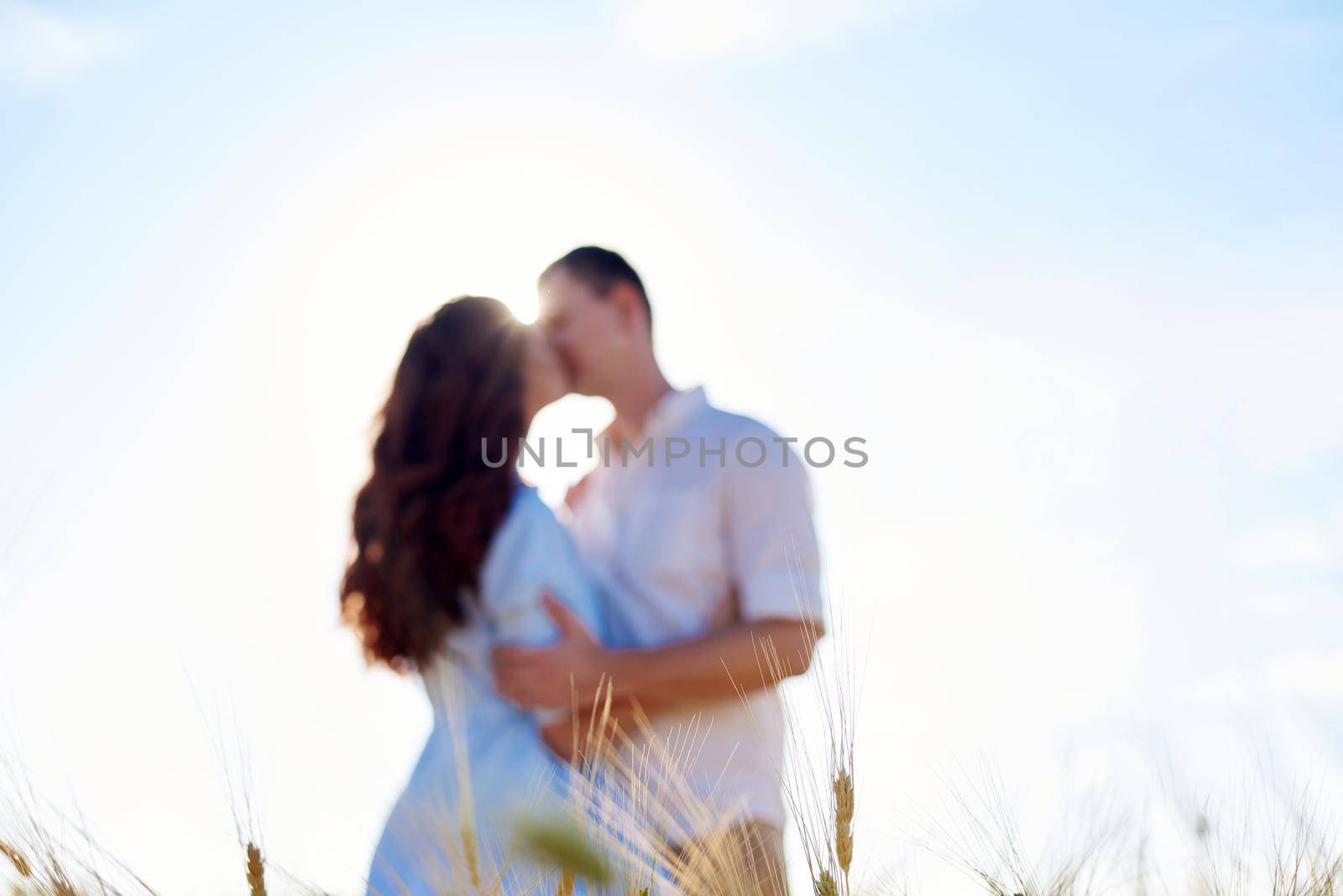 Awesome happy couple have fun in a field sunset background. Lifestyle and travel concept.
