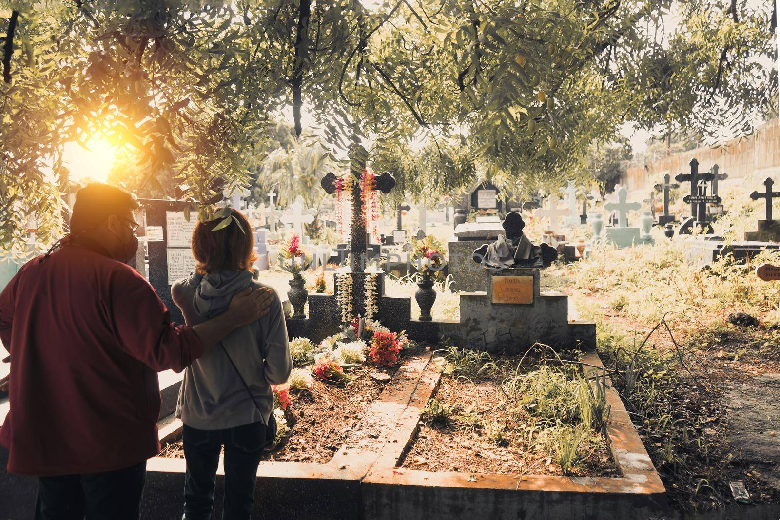 Unrecognizable young couple in front of a mother's grave in a graveyard in Managua Nicaragua