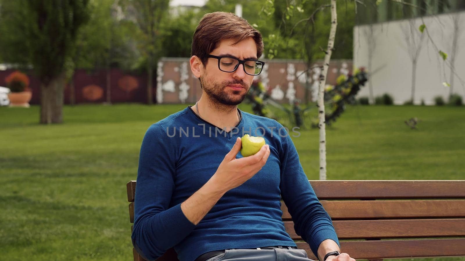 Employee Taking Break Work. Young man Eating a apple as snack. Enjoying an fruit.