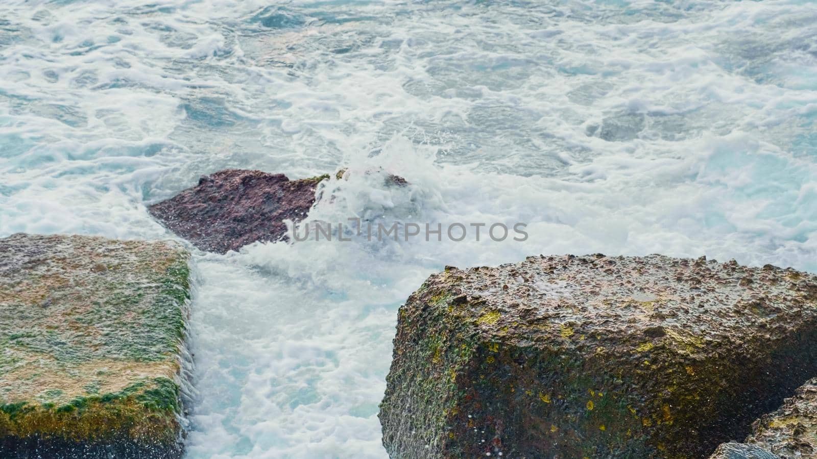 Power of foamy waves breaking over rocks. Stormy Black Sea in cold seasons.