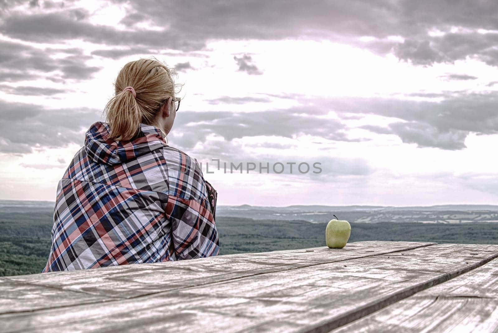 Young blond girl trekker resting at wooden table  by rdonar2