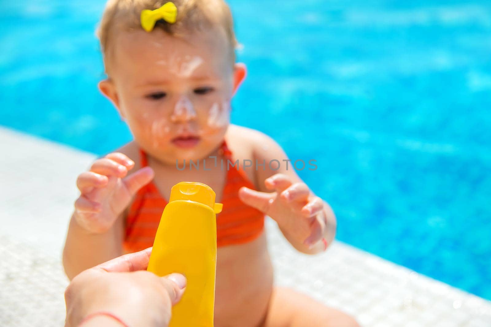 Mother smears sunscreen on the child face. Selective focus. by yanadjana