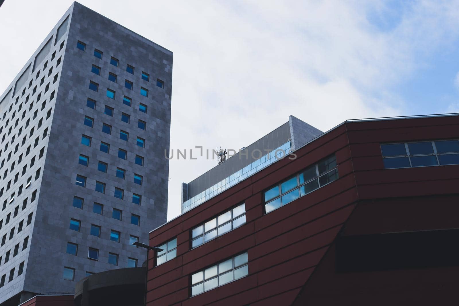 Genova, Italy-January 29, 2022: Beautiful modern high-rise buildings against the sky. 3d illustration on the theme of business success and technology. clouds reflection on the mirror.Industrial zone.