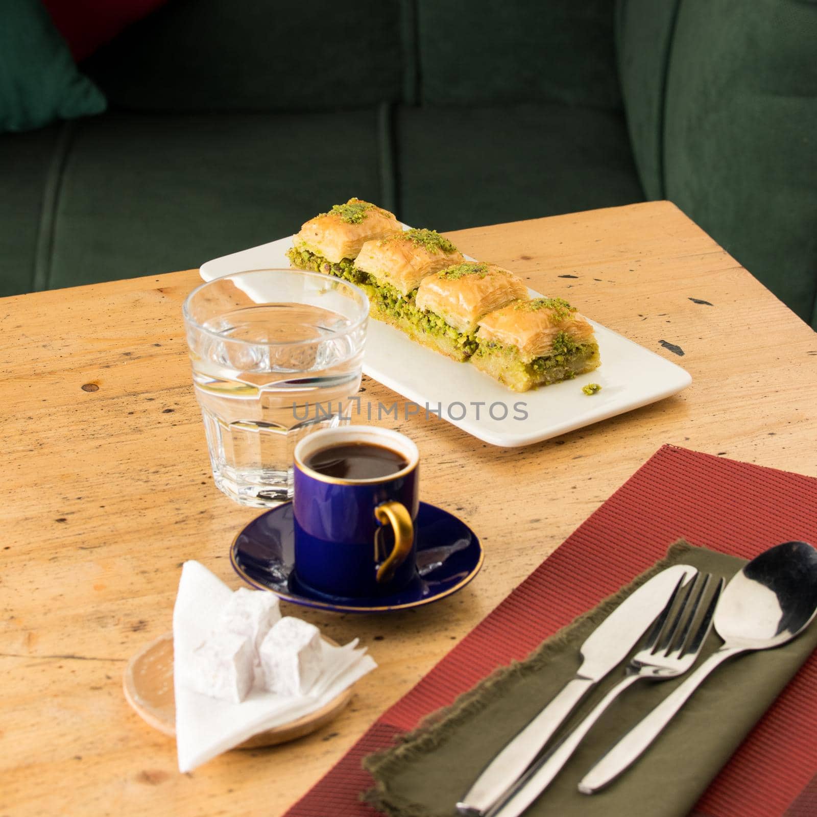 A cup of coffee near glass of water and baklava