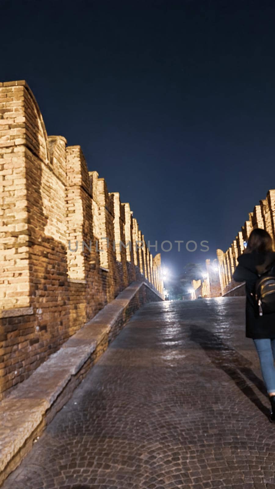 Genova, Italy - July 02, 2022: View of the city and the old harbor (Porto Antico) by night. City lights reflection over the water.