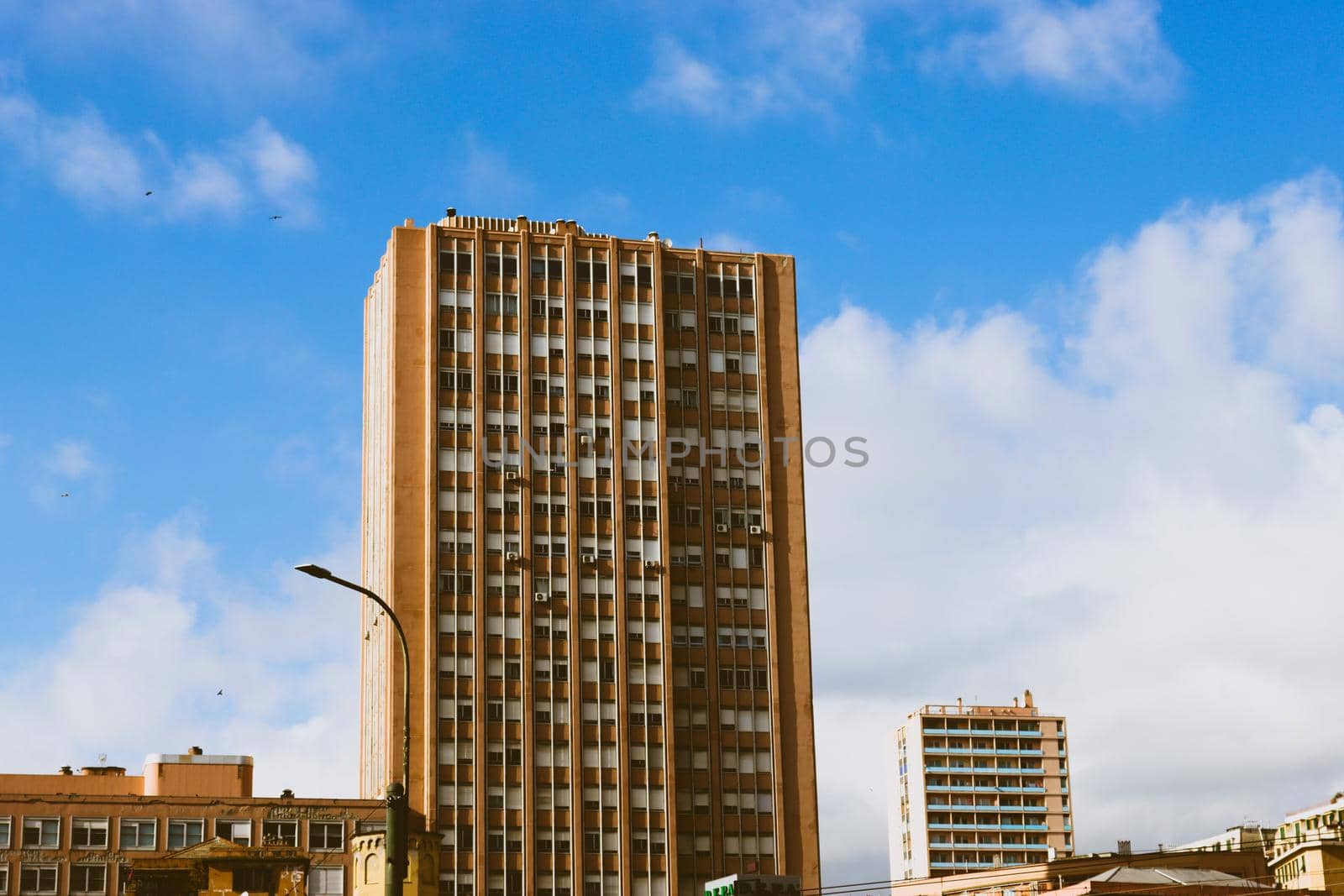 Genova, Italy-January 29, 2022: Beautiful modern high-rise buildings against the sky. 3d illustration on the theme of business success and technology. clouds reflection on the mirror.Industrial zone.