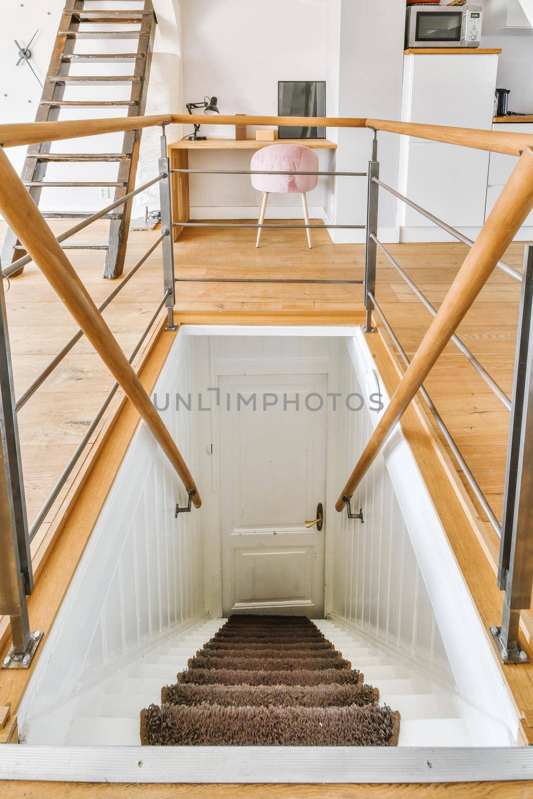 White hallway with wooden stairway leading to second floor of modern luxury apartment with minimalist interior design