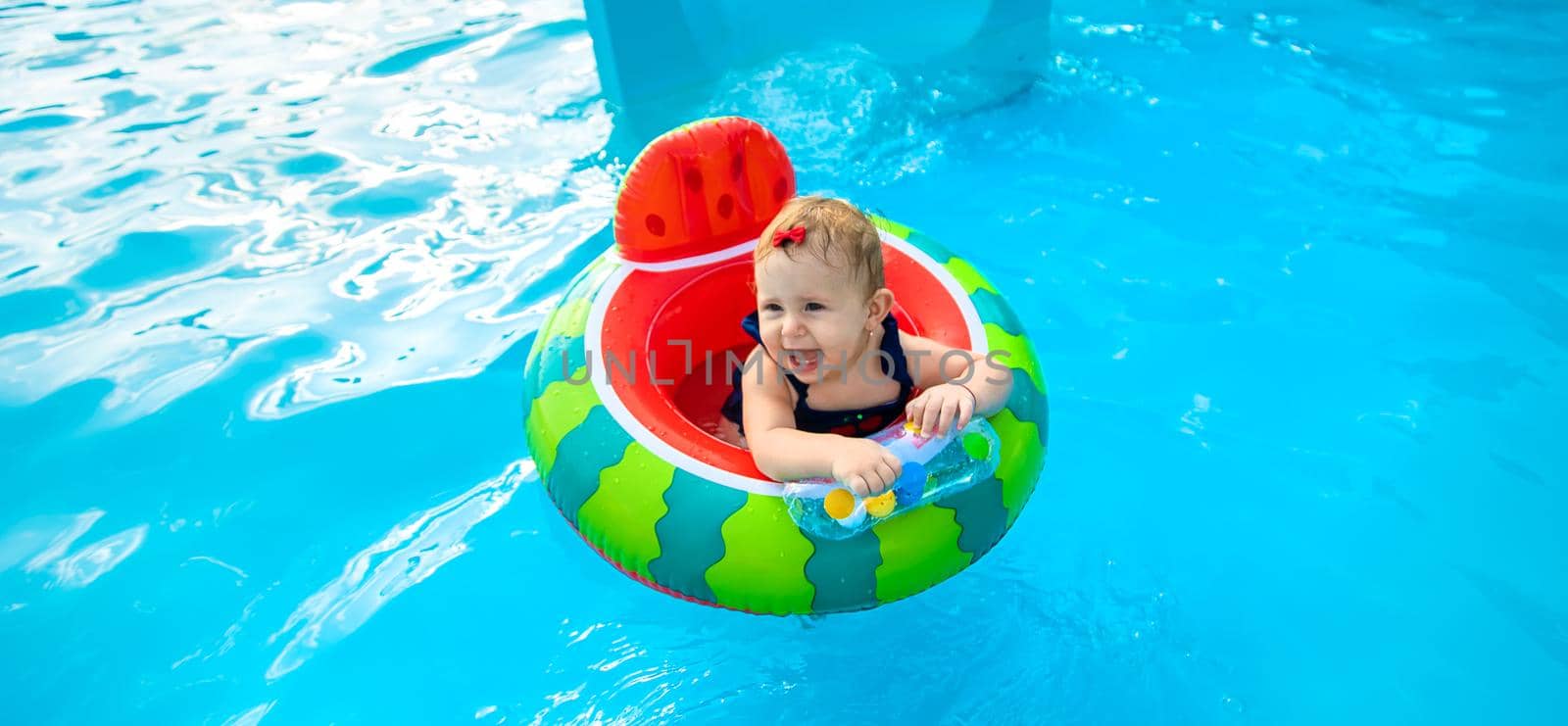 Baby swims in a circle in the pool. Selective focus. Nature.