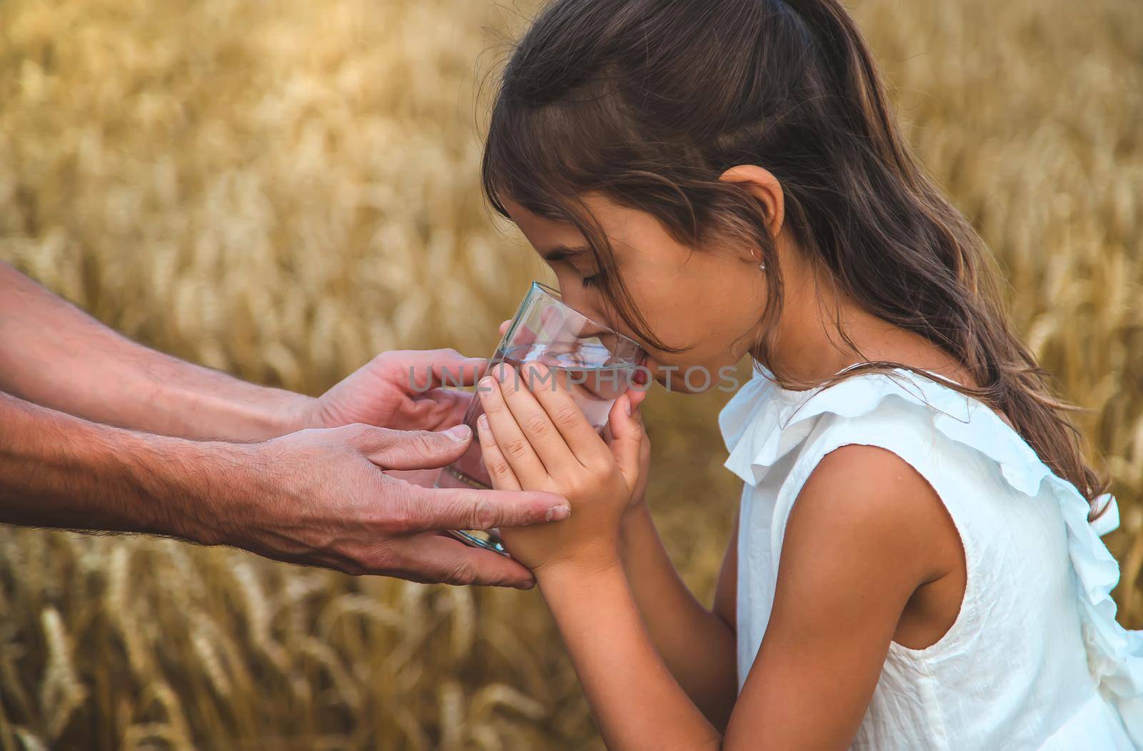 Father and child with a glass of water. Selective focus. by yanadjana