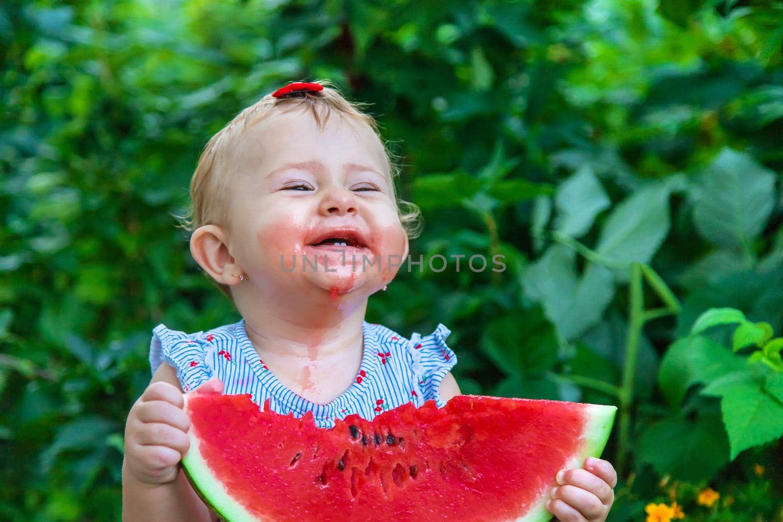 Baby eats watermelon in summer. Selective focus. Food.