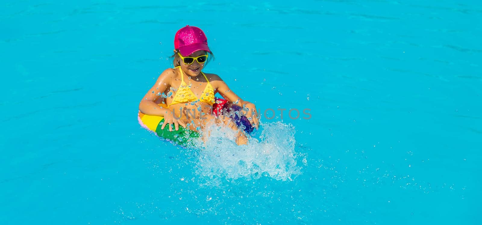 The child swims in the pool in a circle. Selective focus. Kid.