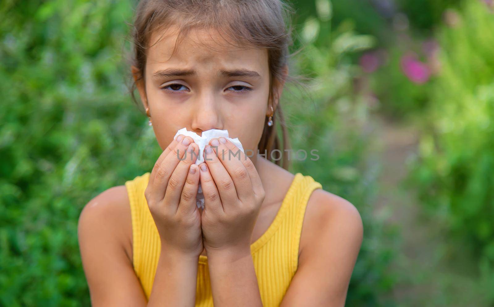 The child is seasonal allergy to flowers. Selective focus. Kid.