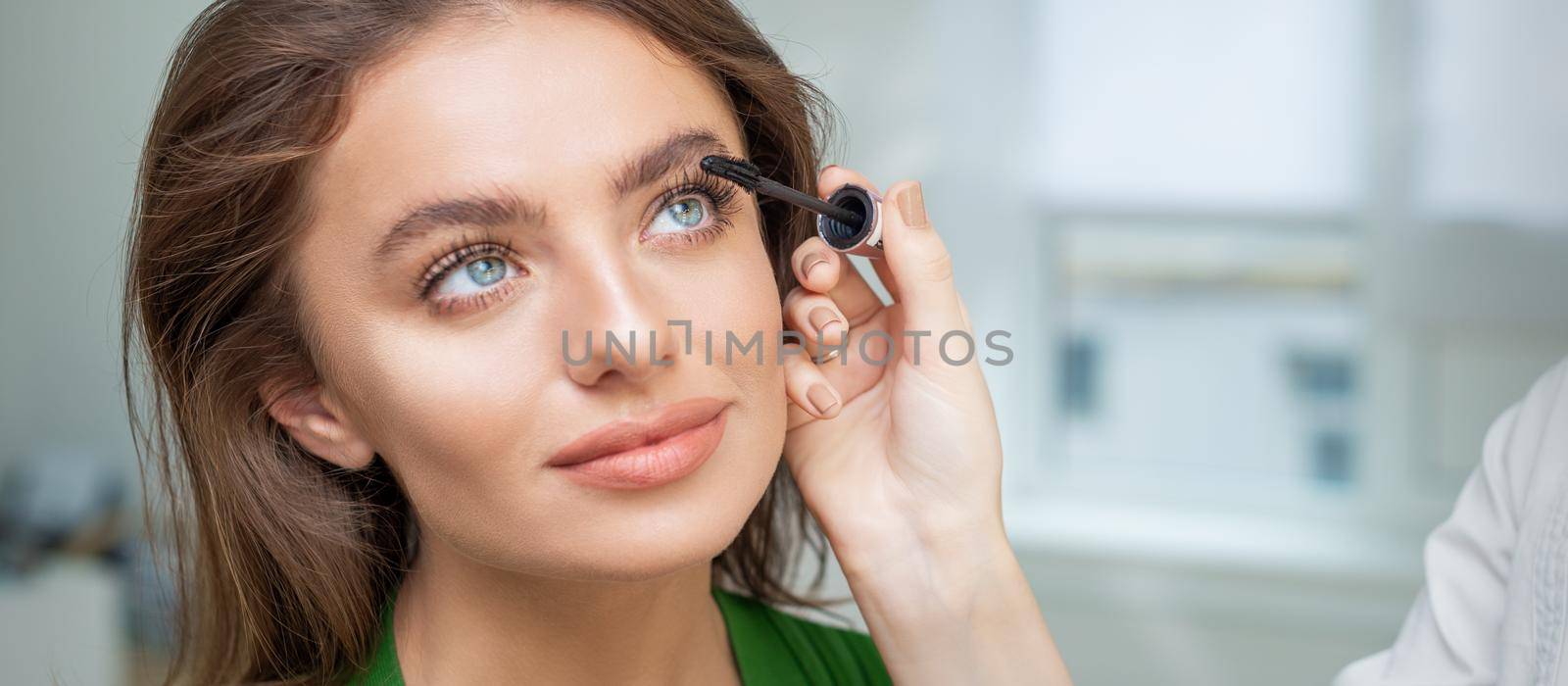 Makeup artist applying mascara on lashes by okskukuruza