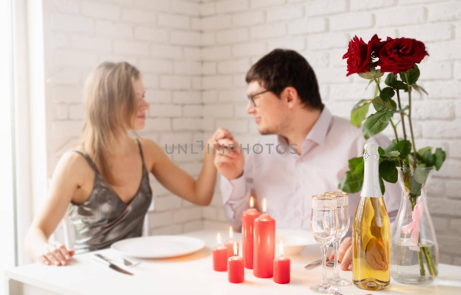 Handsome young man and attractive young woman are spending time together. Man is kissing hand of his beloved woman.