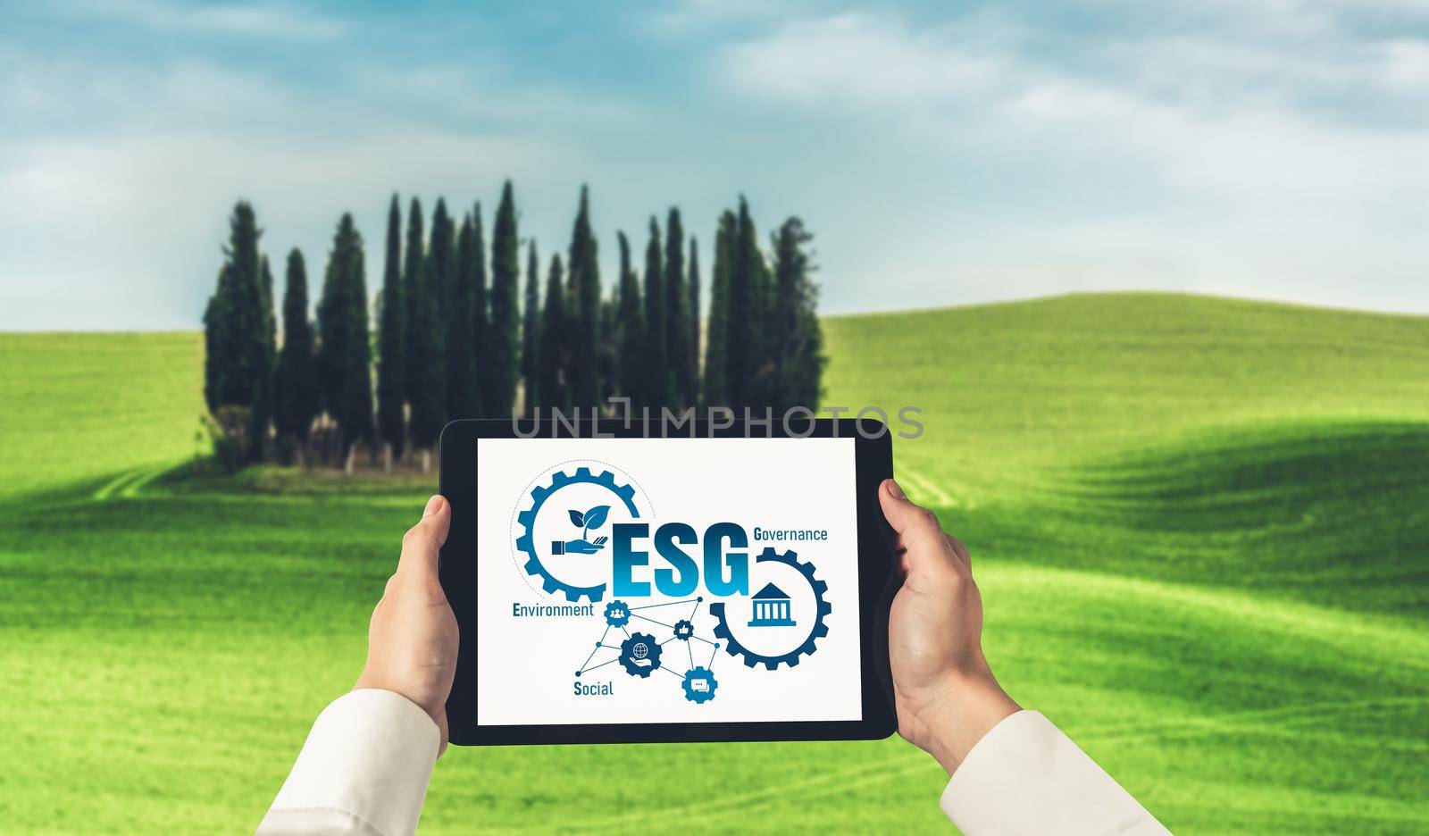 Green business transformation for environment saving and ESG business concept. Businessman using tablet to set corporate goal toward environmental friendly management and alternative clean energy use.