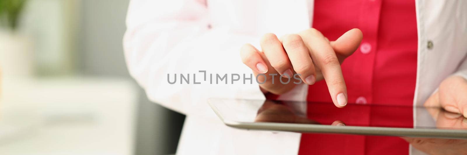 Close-up of professional medical worker use modern tablet device for work. Doctor in uniform with stethoscope hold gadget. Development, medicine concept