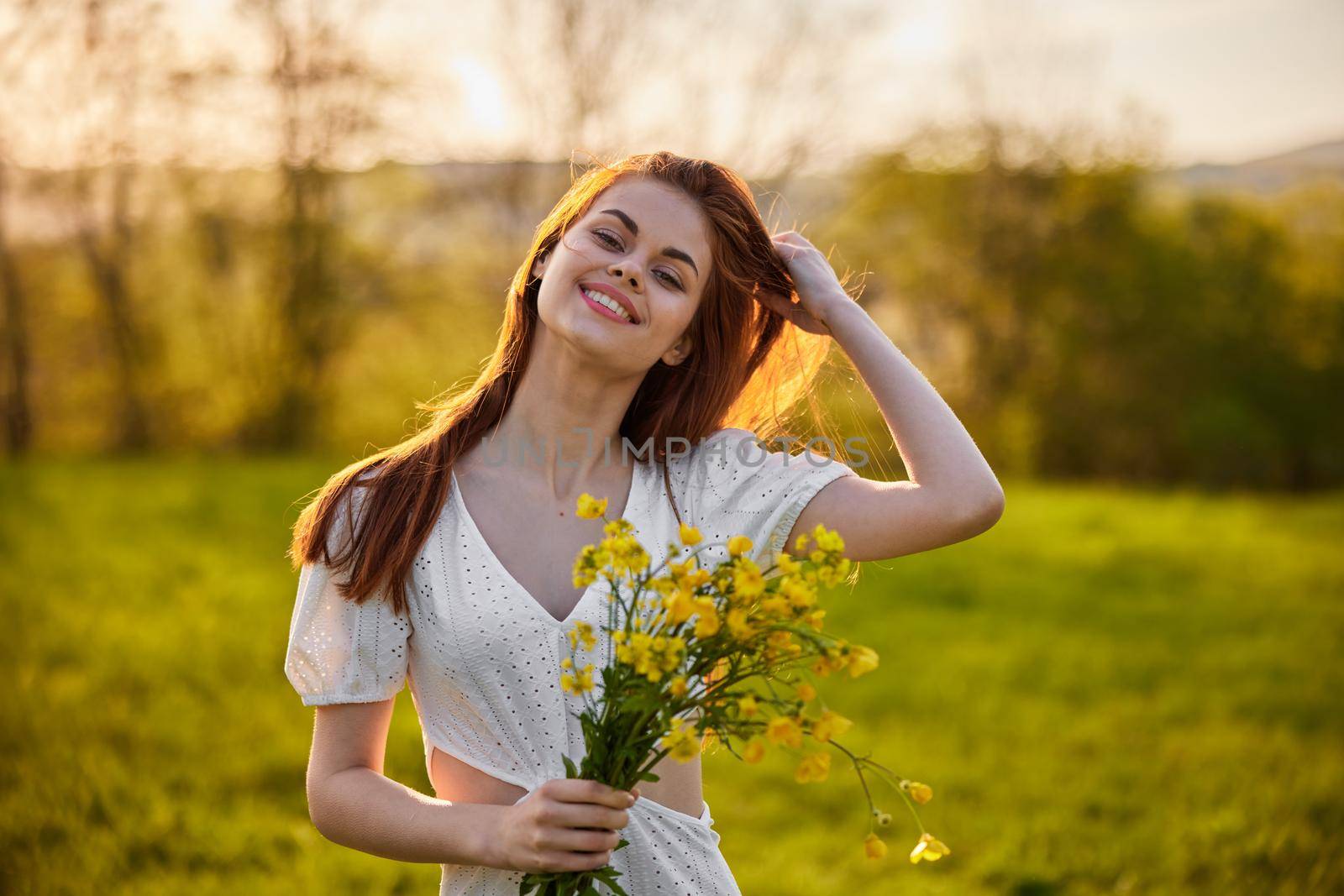 the woman is depicted in the countryside with a bouquet of yellow flowers. High quality photo