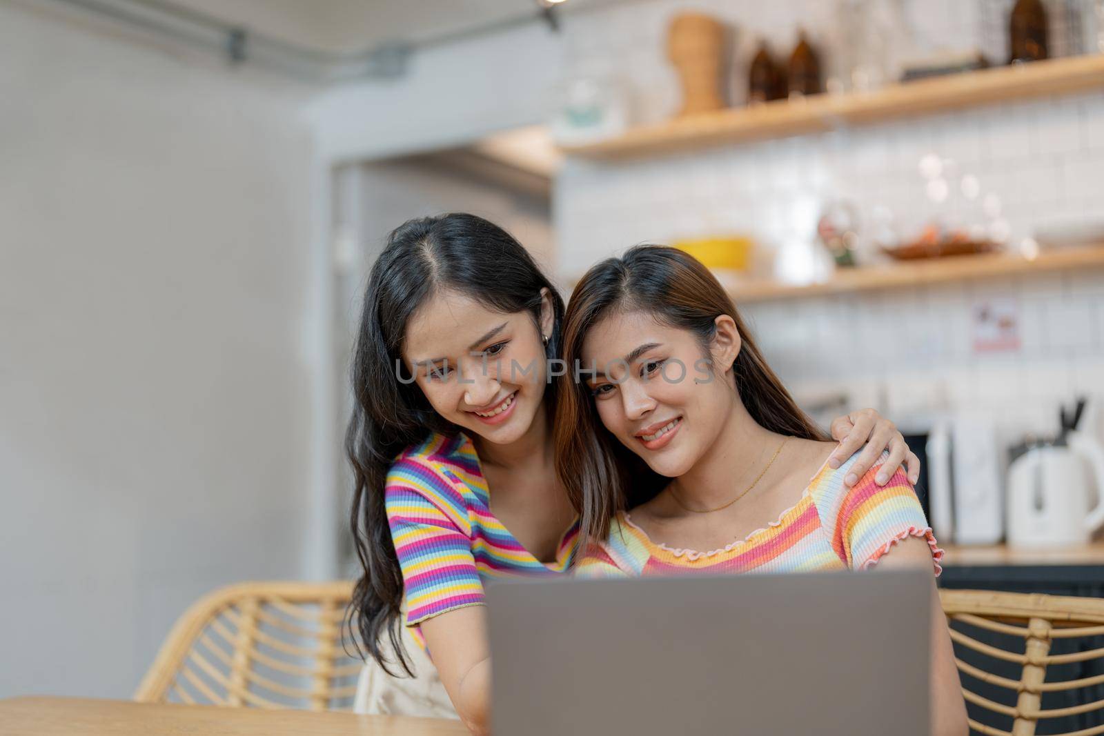 Happy lesbian lgbtq couple in love cuddling, laughing having fun at home. Two diverse pretty affectionate women hugging, bonding. Lgbt relationship concept.