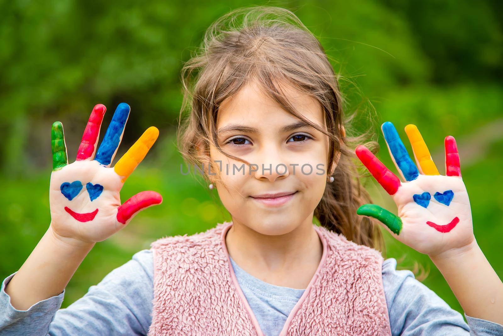 Smile on the hands of a child drawing. Selective focus. Kid.