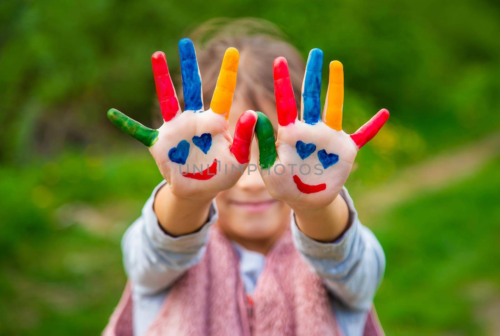 Smile on the hands of a child drawing. Selective focus. by yanadjana