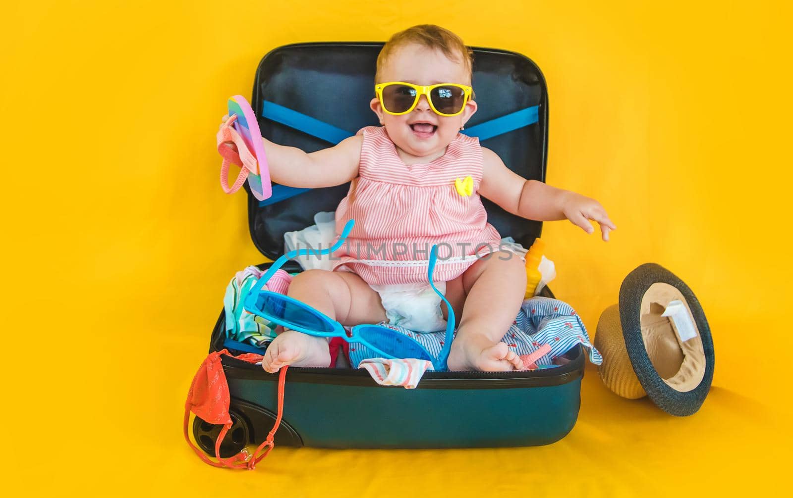 Baby and suitcase with things, luggage travel concept. Going on vacation at sea. Selective focus. Child.