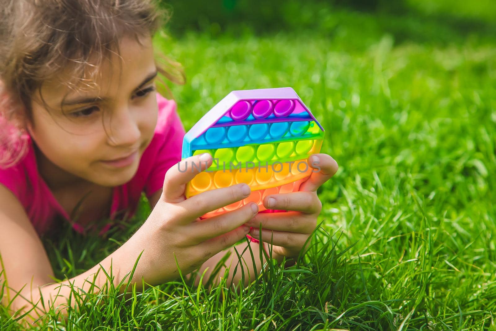 colorful antistress sensory toy fidget push pop it in child hands . Selective focus. nature.