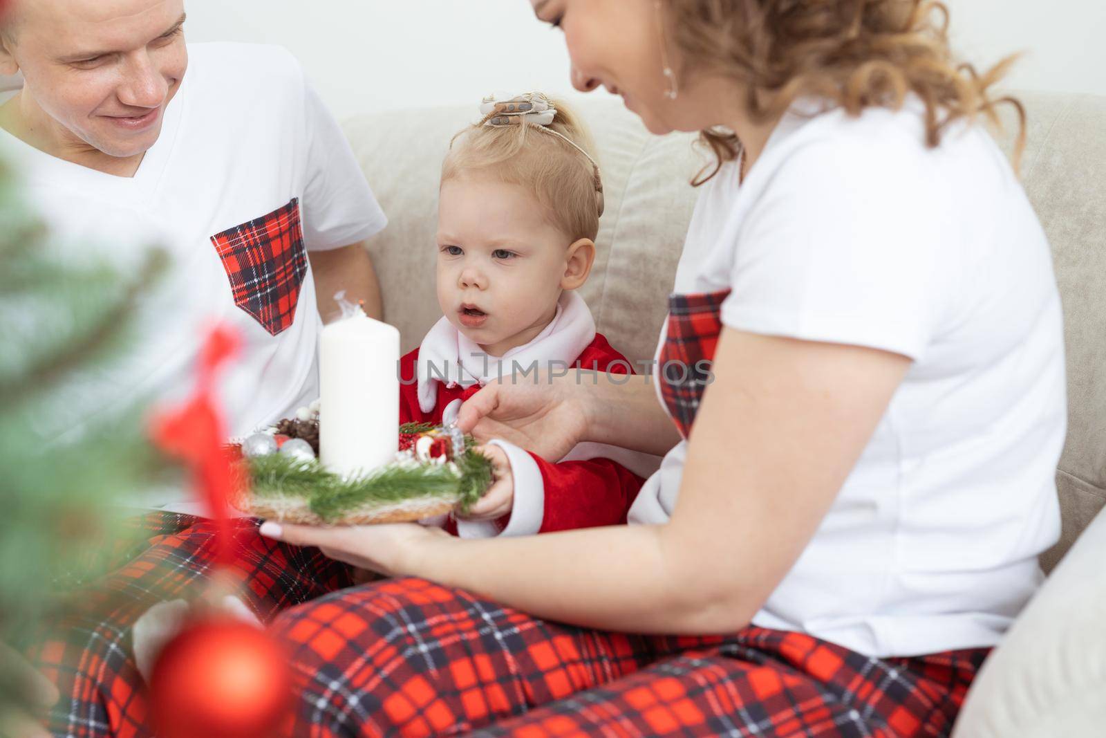 Baby child with hearing aid and cochlear implant having fun with parents in christmas room. Deaf , diversity and health concept by Satura86