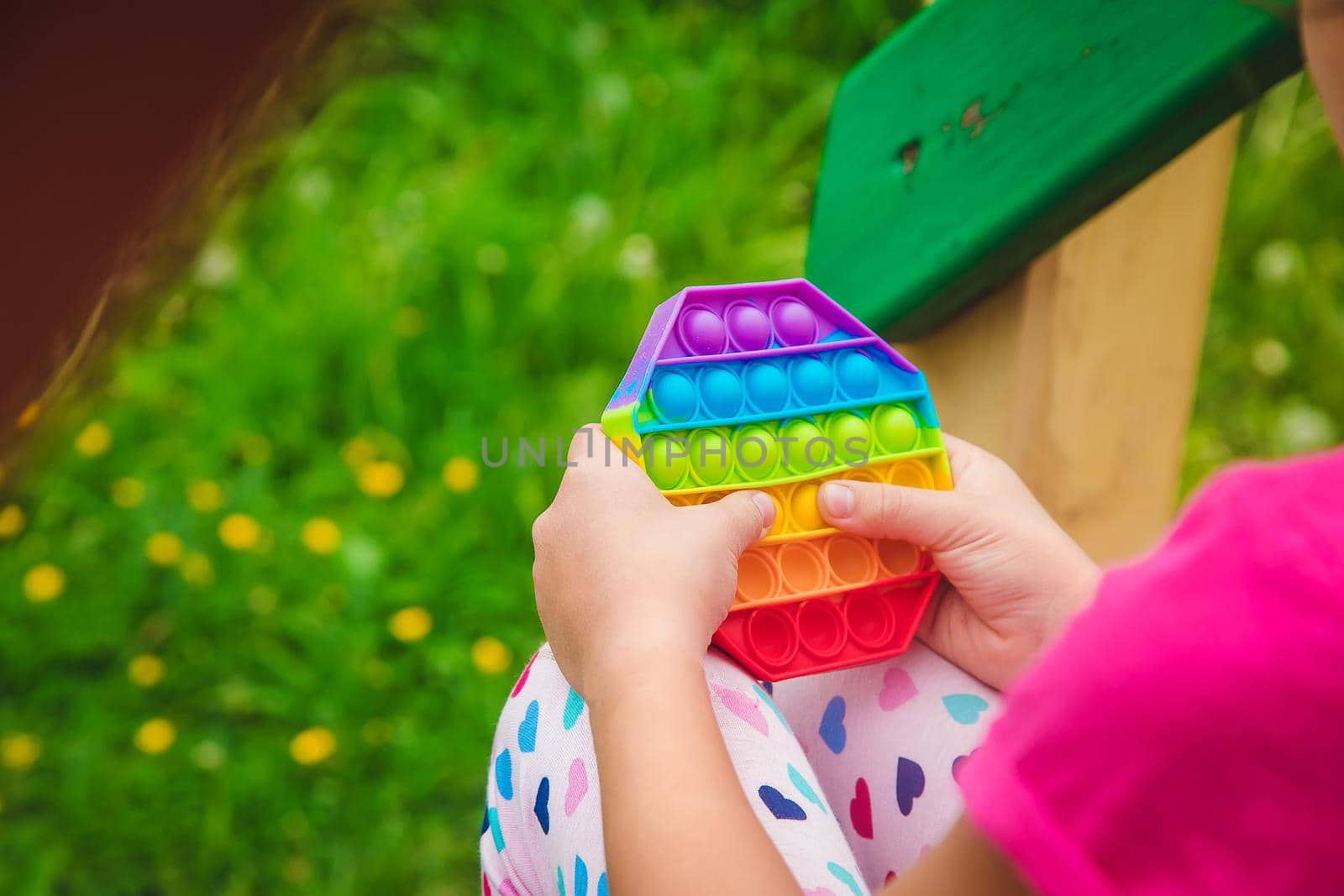 colorful antistress sensory toy fidget push pop it in child hands . Selective focus. nature.