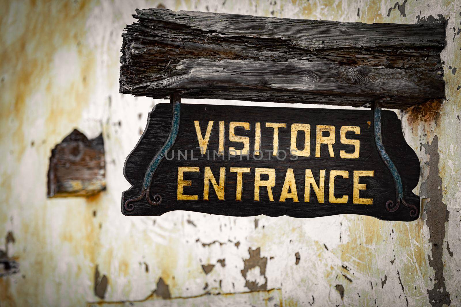 Old visitors entrance sign on wall, California, USA