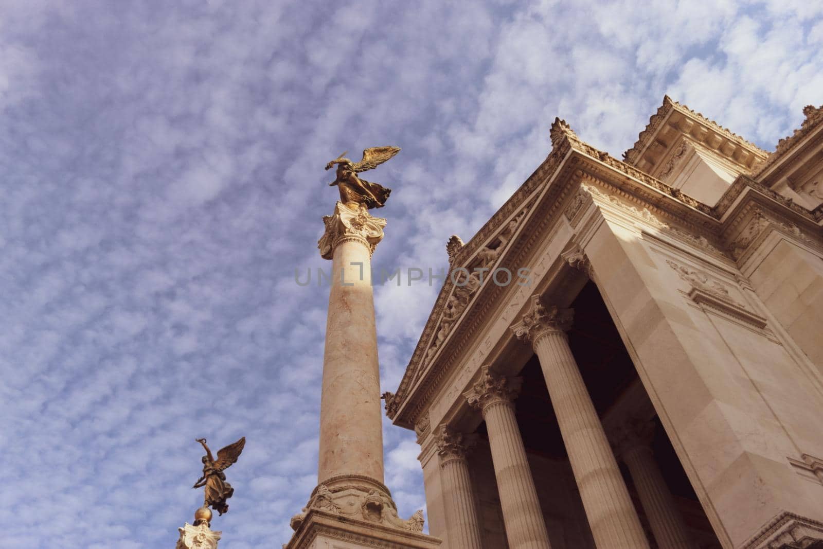 ROME, ITALY - February 05, 2022: Panoramic view around the Colosseum in city of Rome, Italy. Cold and gray sky in the background. Macro photography of the green parks with the old buildings.