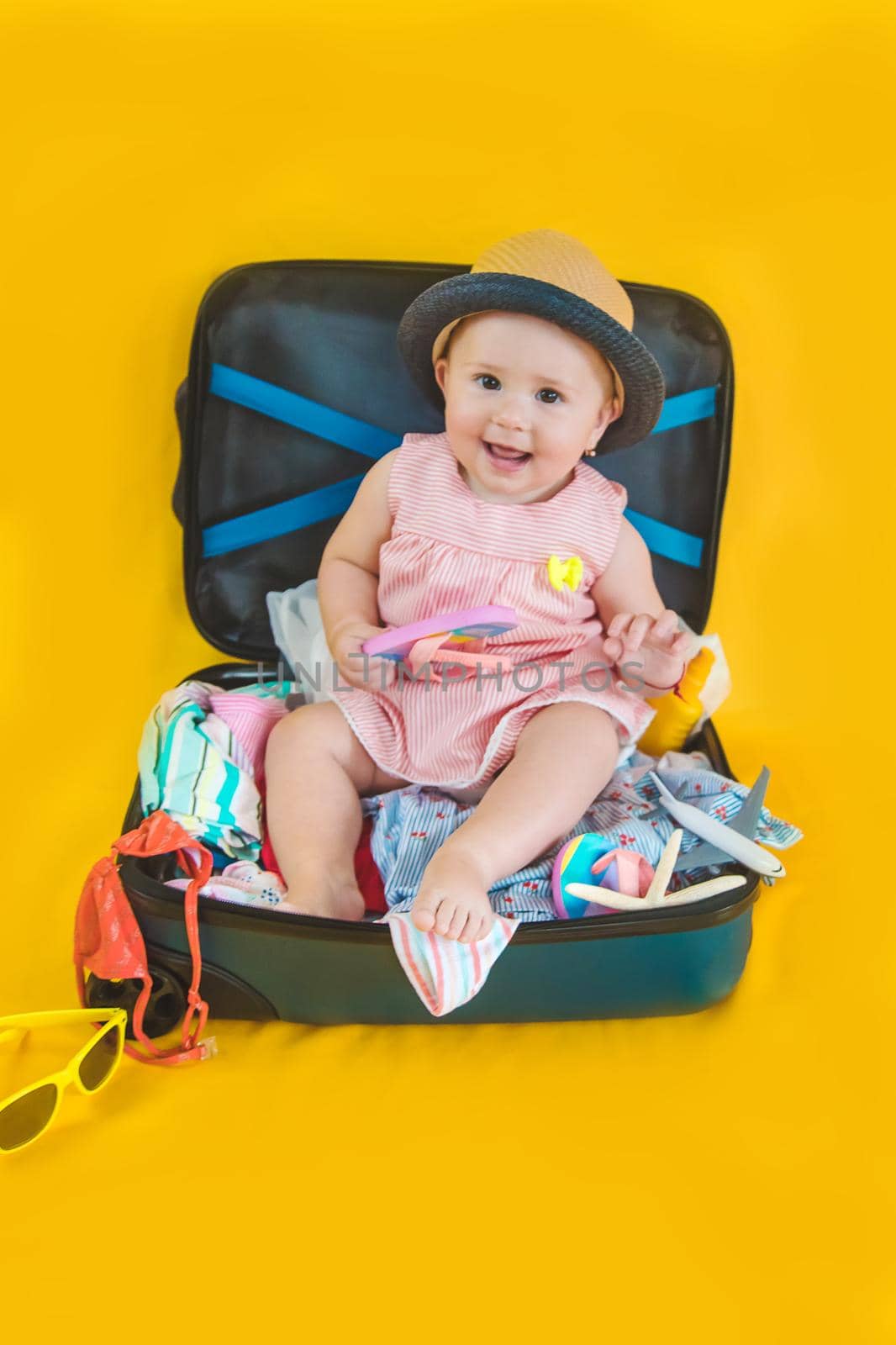 Baby and suitcase with things, luggage travel concept. Going on vacation at sea. Selective focus. by yanadjana