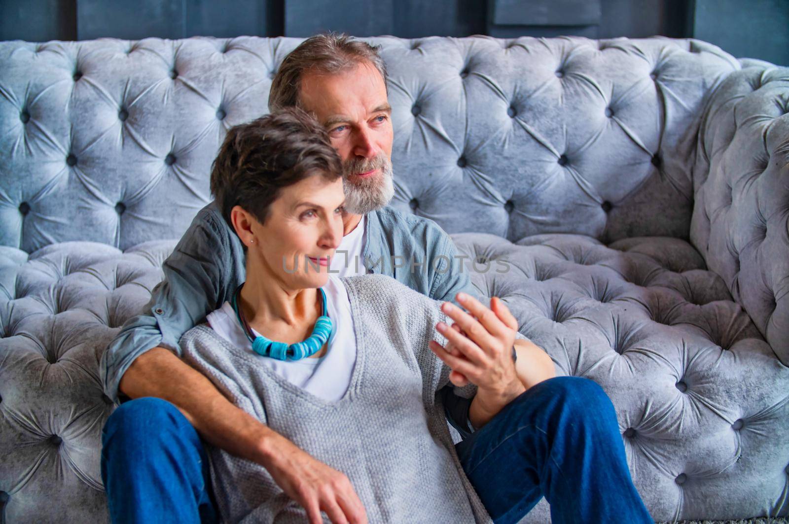 an aged couple sitting near the sofa thinking about something