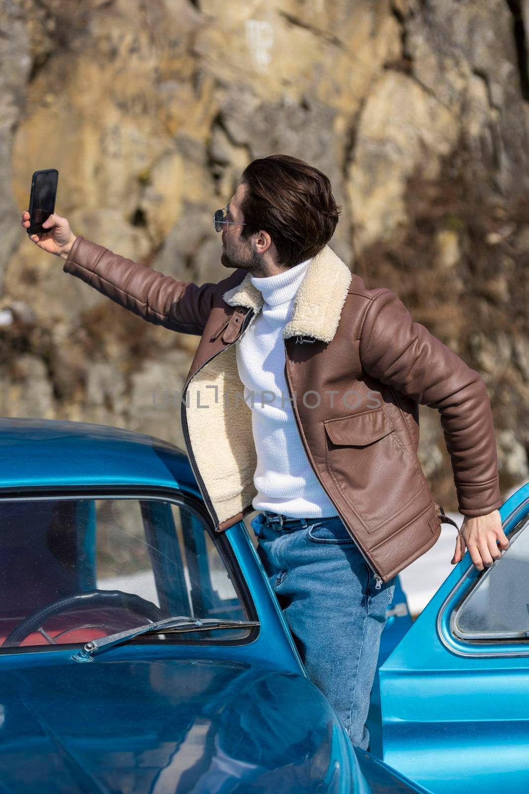 a man takes a selfie on the phone while standing near the car